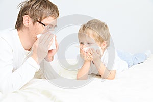 Father and son wiping nose