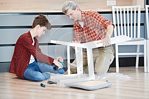 Father and son work together. kitchen chair assembling