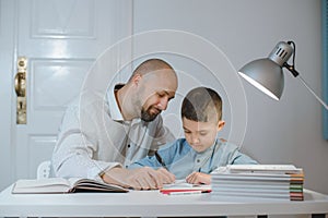 Father and son work together on school homework or homeschooling.
