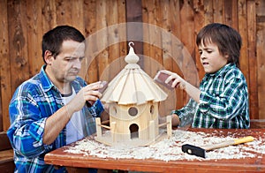 Father and son working on bird house together