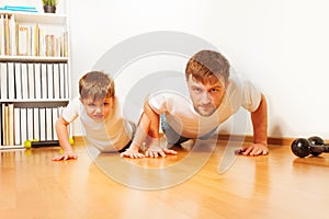 Father and son working up, doing pushups at home