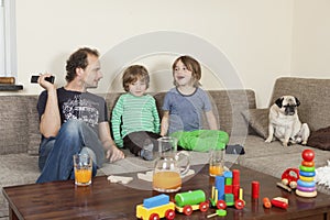 Father with sons and dog on sofa