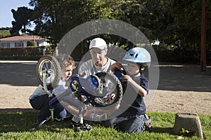 Father and sons fixing bike