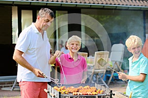 Father with sons grilling meat in the garden