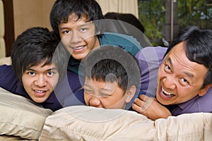 Father and sons having fun in bedroom