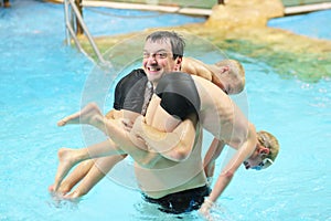 Father and sons having fun in swimming pool