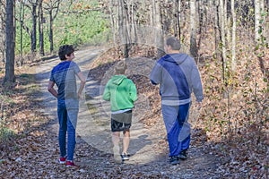 Father and Sons Hiking Through Forest photo