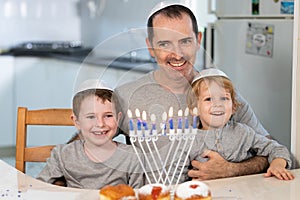 Father and sons with menorah celebrate Hanukkah - Jewish religious holiday