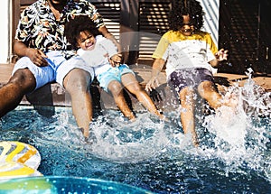 Father and sons playing in a pool