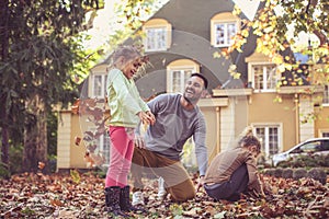 Father spending time together with daughters. Autumn season.