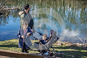 Father with two children is walking along the Aare river in springtime