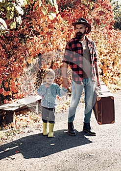 Father with suitcase and his son. Bearded dad telling son about travelling. Traveler with lot experience. Spirit of