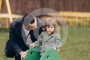 Father Supervising his Daughter on a Playground