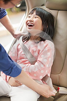 Father take care daughter to fasten a seat belt photo