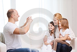 Father taking picture of mother and daughters