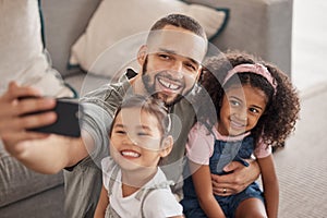 Father taking a selfie on his phone with his children hugging and bonding in their family home. Multicultural father and