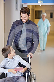 father talking to disabled son in hospital
