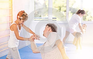 Father teaches his son to use forceful techniques and grips during self defense classes