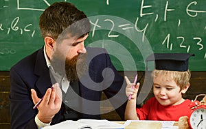 Father teaches son mathematics. Cheerful kid studying with teacher. Arithmetic lesson concept. Teacher in formal wear