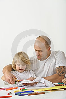 Father teaches son to use scissors photo