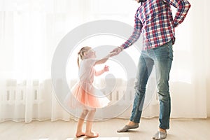 Father teaches to dance his cute little daughter.