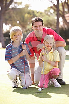 Father Teaching Children To Play Golf