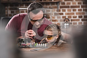 Father teaching daughter to braze concentrated process