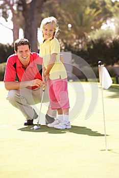 Father Teaching Daughter To Play Golf