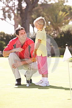 Father Teaching Daughter To Play Golf