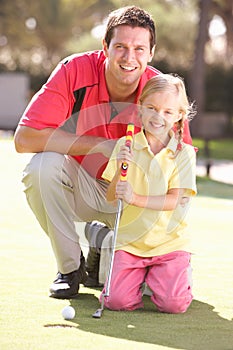 Father Teaching Daughter To Play Golf