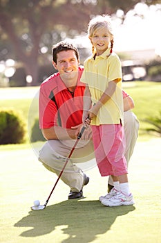 Father Teaching Daughter To Play Golf