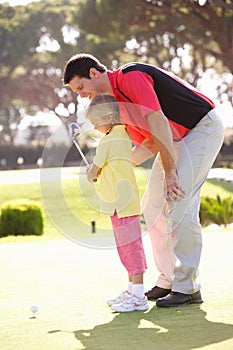 Father Teaching Daughter To Play Golf