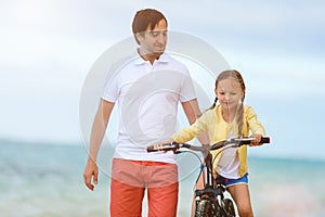 Father teaching daughter to ride bike