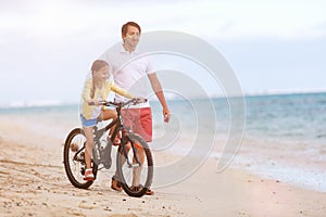 Father teaching daughter to ride bike