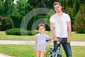 Father teaching daughter to ride a bike