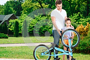 Father teaching daughter to ride a bike