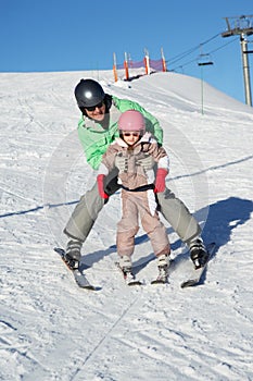 Father Teaching Daughter To Ski Whilst On Holiday