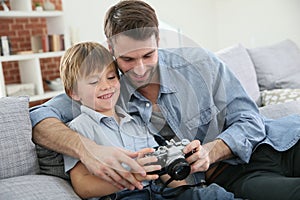 Father teaching his son son using a camera