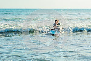 Father teaching his young son how to surf in the sea on vacation