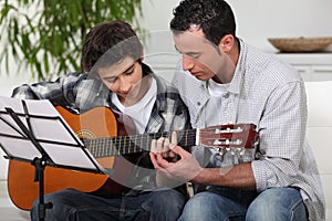 Father teaching son the guitar