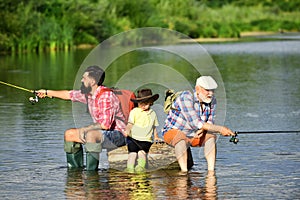 Father teaching son how to fly-fish in river. Anglers. 3 men fishing on river in summer time. Father, son and