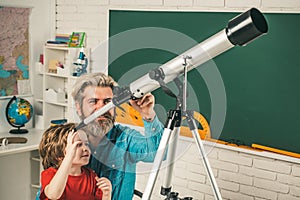 Father teaching son. Pupil watching stars with a teacher and hold Astronomy telescope. Elementary school and education.