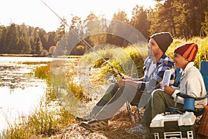 Father Teaching Son To Fish By Lake