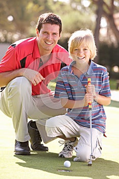 Father Teaching Son To Play Golf