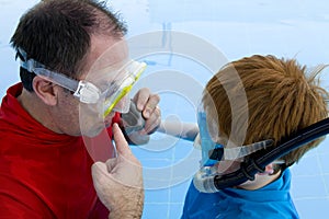 Father teaching son to snorkel