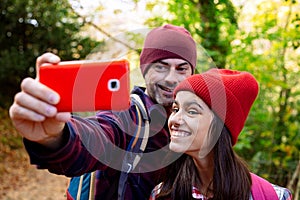 Father and teenage daughter taking a selfie while hiking in autumn