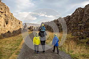 Father with three children, enjoying a sunny day in Thingvellir National Park rift valley, Iceland