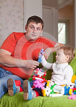 Father and three-year child plays in home