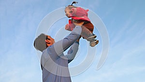 Father threw a happy child into the blue sky. Dad plays with his little daughter in the park. concept of happy family