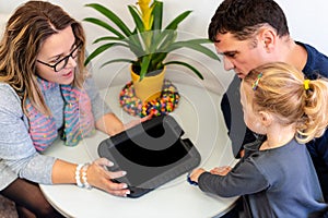 Father and toddler daughter in therapist office during counselling meeting.